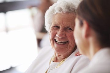 Senior woman smiling at caregiver