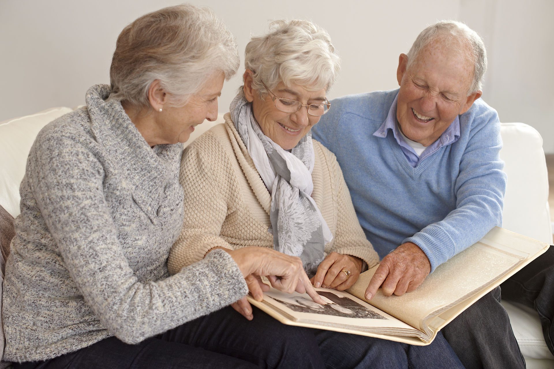 three seniors looking at a photo album