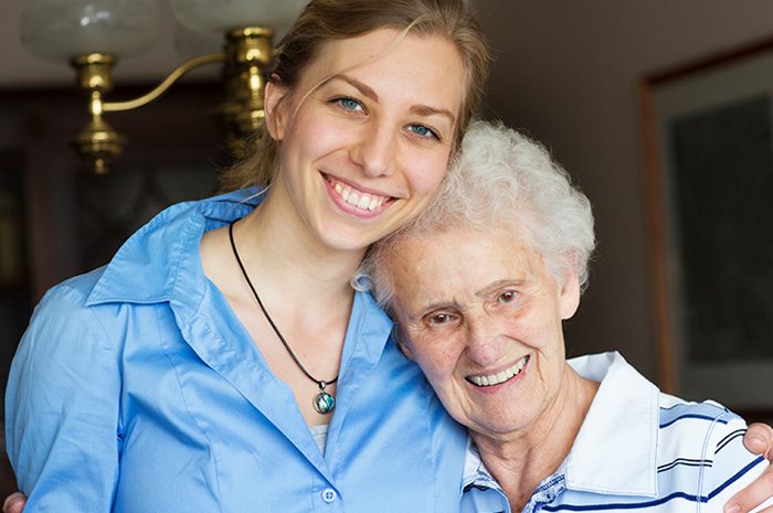 a caregiver with her arm around a senior woman's shoulders