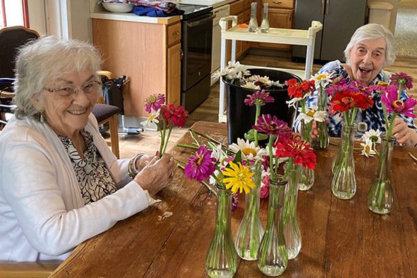 two senior ladies putting flowers in vases